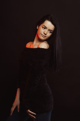 Naklejka premium Model test with luxurious lady woman in knitted sweater posing over a black studio background