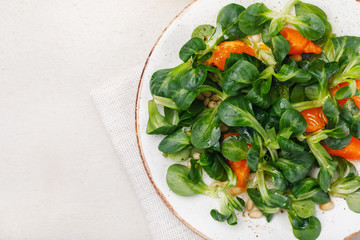 Delicate Korn salad with pine nuts and tangerine. Top view of food with space for text
