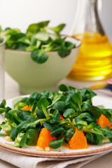 Freshly prepared Korn salad with pine nuts and tangerine. Vegetarian dish