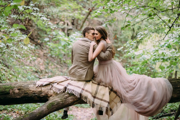 Fototapeta na wymiar Romantic couple is gently hugs on the log. Autumn wedding