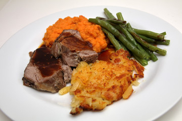 gigot with swiss hash browns, mashed carrots and beans