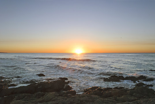 Sun Rising in the middle of a rocky sea at Punta del Este, Uruguay