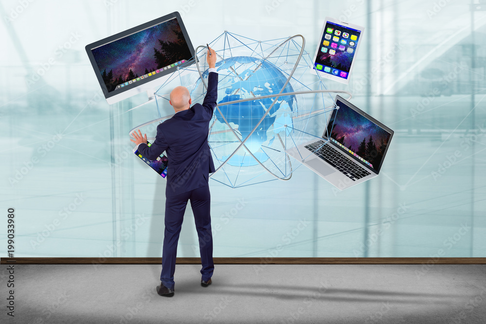 Poster businessman in front of a wall with a computer and devices displayed on a futuristic interface with 