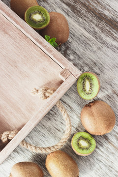 Green kiwis and mint leaves in the wooden tray