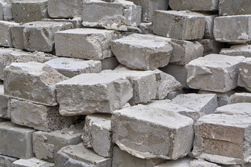 Grey stone bricks stacked against the wall at home.