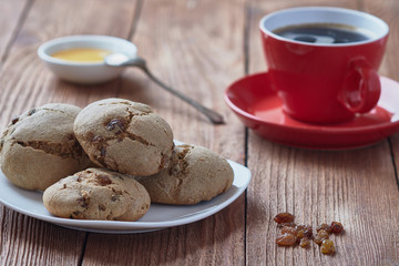 Delicious homemade oatmeal cookies with honey and raisins. Red coffee cup.