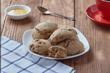 Delicious homemade oatmeal cookies with honey and raisins. Red coffee cup.