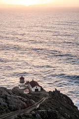 Lighthouse on cliff with ocean