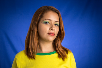 Brazilian woman fan celebrating on football match on blue background.