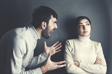 young angry man and woman on dark background