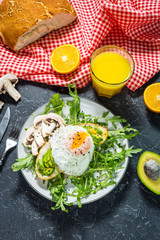 Tasty sandwiches with avocado and egg, arugula on black stone background. Delicious breakfast