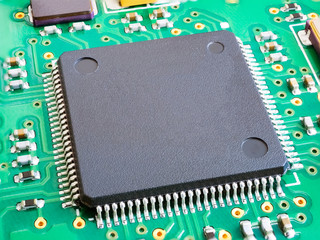 Close-up of electronic circuit board PCB with components: microchip, processor, integrated...
