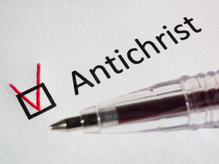 Questionnaire. Red pen and the inscription ANTICHRIST with check mark on the white paper. Close-up background. High-quality macro photography.