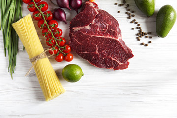 Raw meat, different vegetables and fruits on wooden background. Healthy food. Top view. Flat lay.