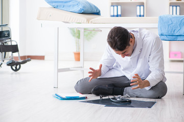 Doctor sitting on the floor in hospital