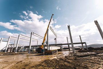 Details of construction site with crane lifting prefabricated concrete framework, unloading and cargo details