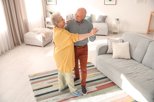 Elderly couple dancing in living room