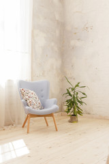 Modern blue armchair in a room with white curtains