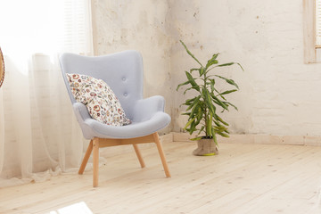 Modern blue armchair in a room with white curtains