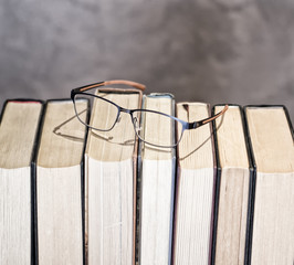 set of books ordered with glasses on them