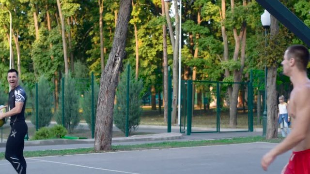 Basketball freestyle, a player jumps over a teammate and makes a slam dunk. Basketball training outdoors in the park. Healthy lifestyle. Video in full hd format slow motion 