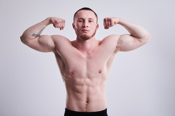 Fototapeta na wymiar Young man showing his strong biceps