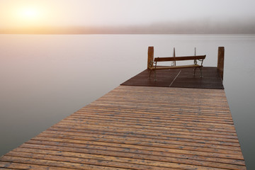 Empty footbridge with a bench on a lake Altausseer at sunrise