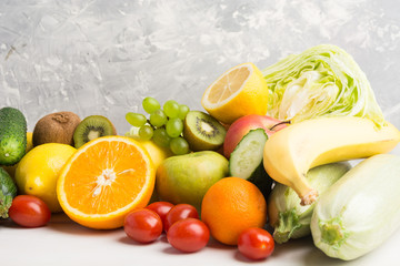 Fresh fruits and vegetables on grey background with copy space