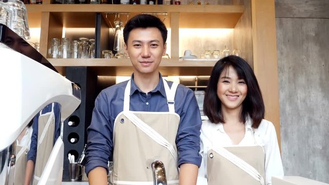 Team asian barista standing at counter with smiling.