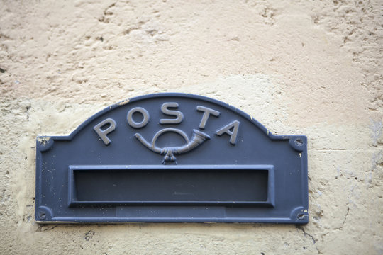 the Old Italian mailslot with traditional symbol of trumpett and message Posta - Mail.