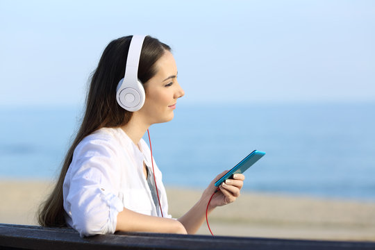 Girl listening to music relaxing on the beach