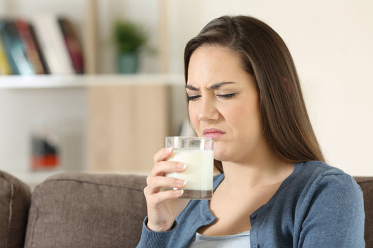 Woman disgusted tasing milk with bad flavor