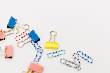 Top view of office accessories, paper clips, on white background with space for your text or photo