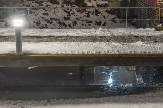 G&aring;ngbro &ouml;ver vattnet mellan husen i J&auml;rla sj&ouml; fotat en vinter natt