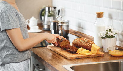 hands women cut bread and cheese for breakfast