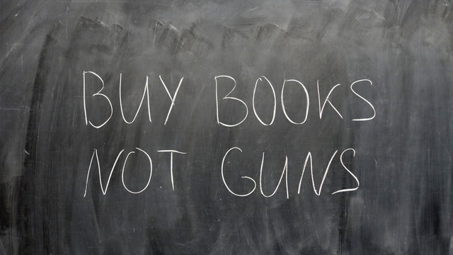 “Buy books, not guns” sign written by a child on a chalkboard