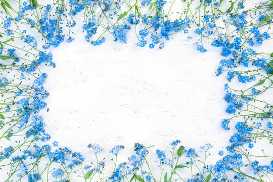 Gentle Frame of blue forget-me-not flowers on white background