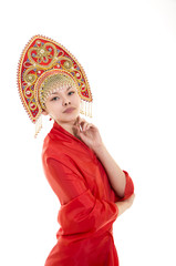 Portrait of smiling girl in kokoshnik (headdress) and red dress on white background.