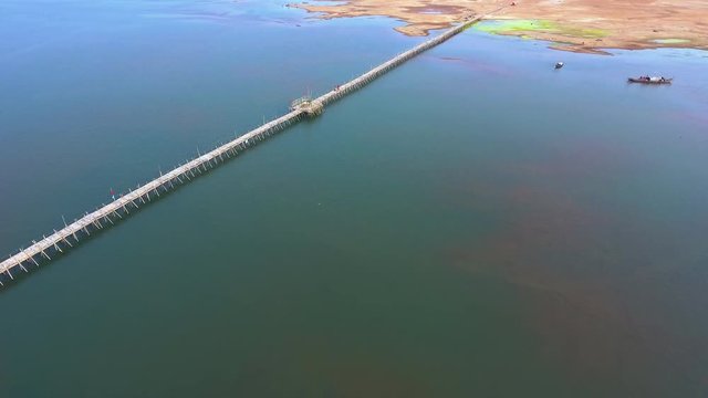 Aerial drone shot : slider shot of a long bamboo bridge over mekong river. 