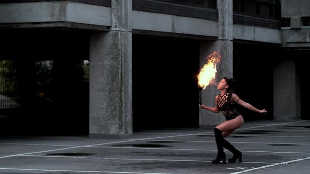 Fire artist entertainer breathes burning flame in the dark