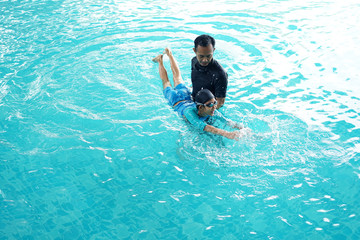 Father teaching daughter to swim