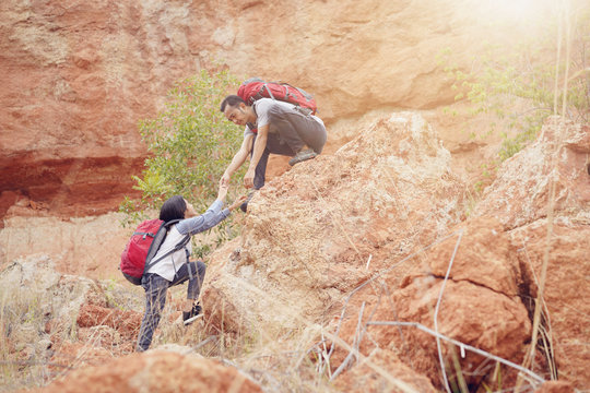 Father and daughter hiking climbing in mountains together success idea concept