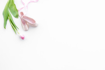 Obraz na płótnie Canvas Ballet shoes near delicate flowers on white background top view copy space