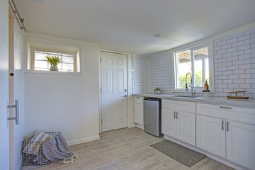 Kitchen interior with white cabinets, tiled wall.