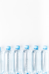 Drinking water in bottles on white background top view copy space