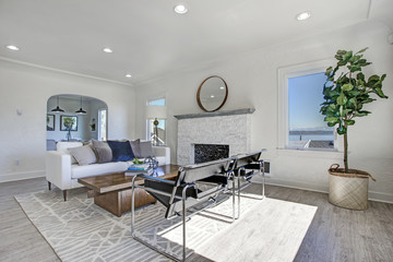 White living room area with fireplace and wood cocktail table.