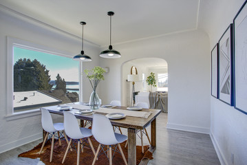 Dining room with white walls and wooden table.