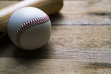 baseball and baseball bat on wooden table background, close up