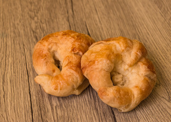 Croissants pastry on the wooden table. The croissants is a bread product made of a layered yeast-leavened dough with butter rolled and folded several times in succession, then rolled into a sheet.