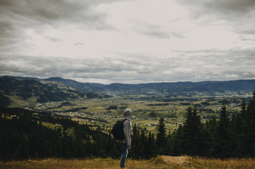 Woman carrying a sports backpack and look somewhere on the moutains.